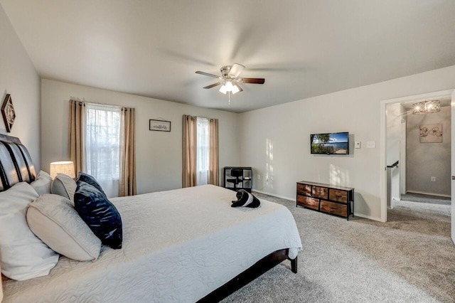 carpeted bedroom with baseboards, multiple windows, and a ceiling fan