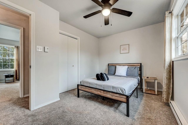 bedroom with a baseboard radiator, multiple windows, and carpet