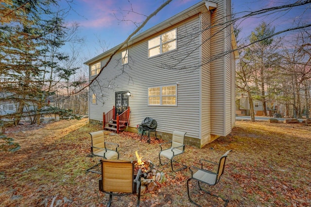 rear view of house with entry steps and a fire pit