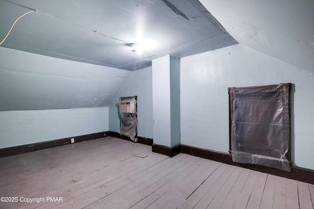 bonus room featuring wood-type flooring, baseboards, and vaulted ceiling