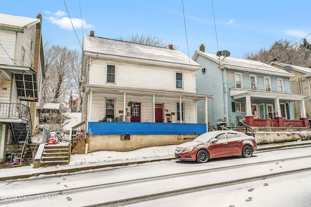 view of front of house featuring covered porch and stairs