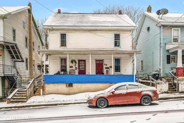 american foursquare style home featuring a porch and stairway