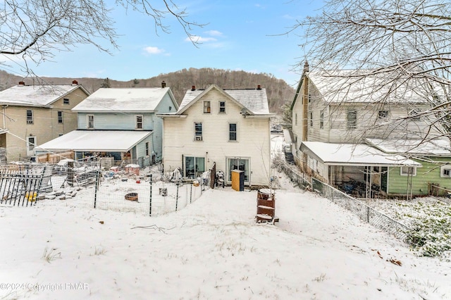 snow covered house with fence