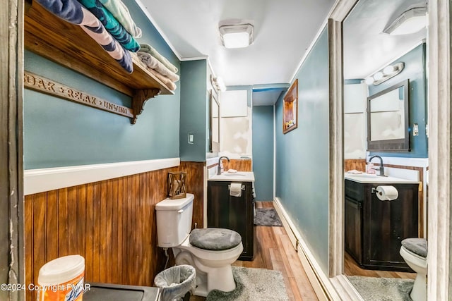 bathroom featuring a wainscoted wall, vanity, toilet, and wood finished floors