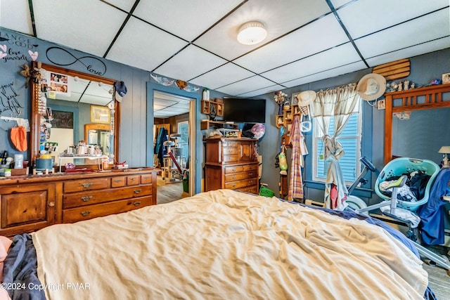 bedroom with a drop ceiling and wood finished floors