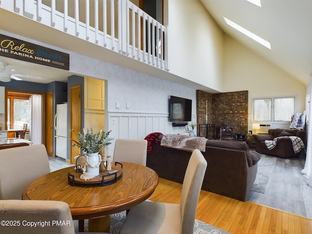 dining area with a wealth of natural light, a skylight, and wood-type flooring