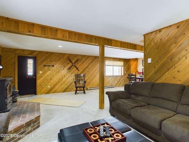 living room featuring a baseboard heating unit, carpet floors, plenty of natural light, and a wood stove