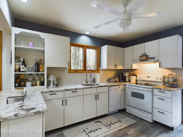 kitchen featuring white cabinetry, sink, light stone counters, and white appliances