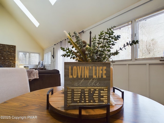 dining space featuring a wealth of natural light, high vaulted ceiling, and a skylight