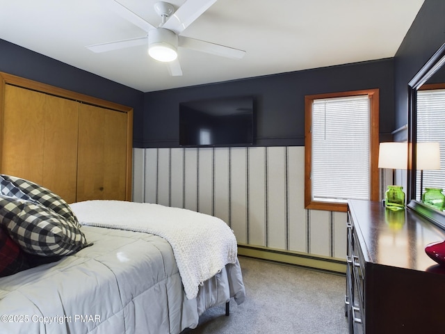 carpeted bedroom featuring a closet, ceiling fan, and baseboard heating