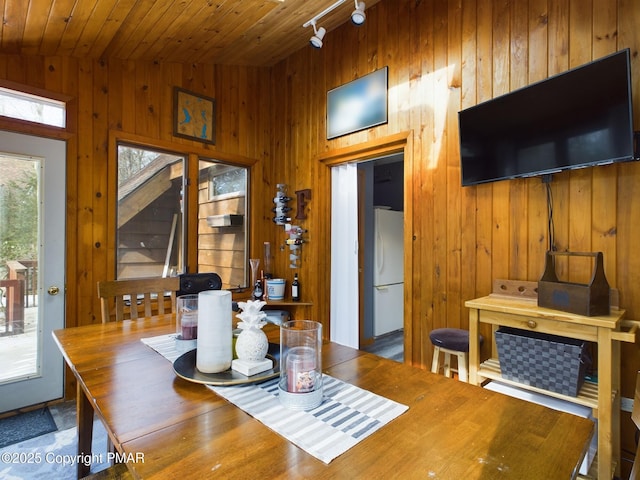 dining room featuring wood ceiling and wood walls