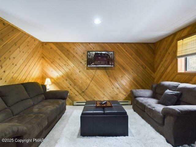 living room with a baseboard radiator, carpet floors, and wood walls