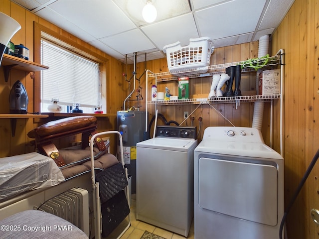 washroom with electric water heater, washer and dryer, and wooden walls