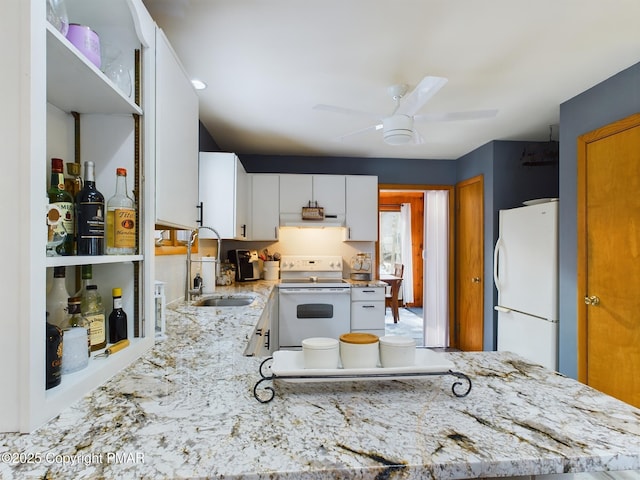 kitchen with light stone countertops, sink, white cabinets, and white appliances