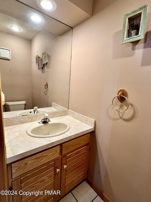 half bathroom featuring vanity, toilet, and recessed lighting