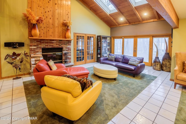 living area featuring tile patterned flooring, french doors, a skylight, wooden ceiling, and high vaulted ceiling