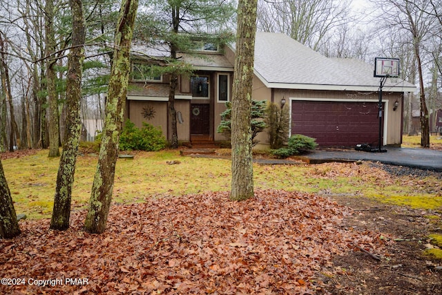 view of front of property featuring a garage, roof with shingles, and aphalt driveway