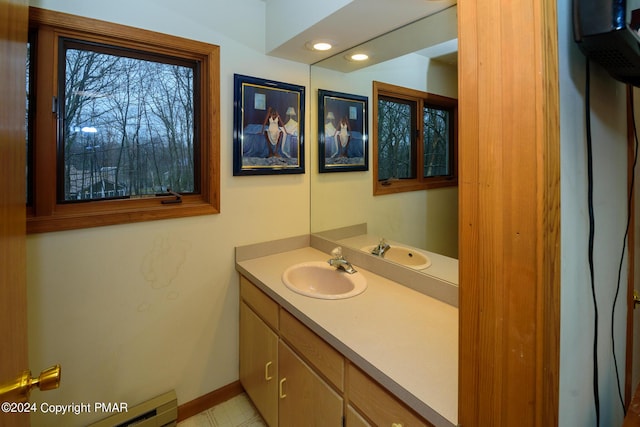 bathroom with baseboard heating, recessed lighting, vanity, and baseboards