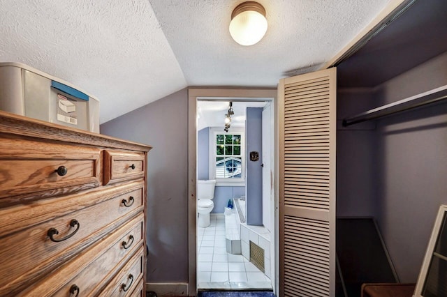 325 Mt Nebo Rd, East Stroudsburg, PA 18301 - tiled bedroom with a textured ceiling, lofted ceiling, a closet, and connected bathroom