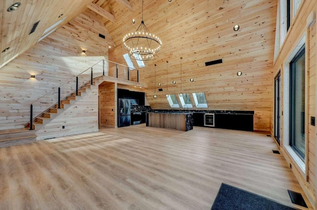 4142 Calendula Ct, Pocono Pines, PA 18350 - unfurnished living room with high vaulted ceiling, wood walls, a chandelier, light wood finished floors, and a wooden ceiling with exposed beams