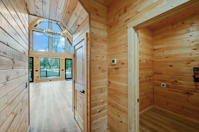 4142 Calendula Ct, Pocono Pines, PA 18350 - hall with a chandelier, wooden walls, wood finished floors, and vaulted ceiling