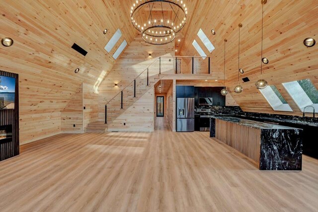 4142 Calendula Ct, Pocono Pines, PA 18350 - kitchen featuring appliances with stainless steel finishes, wooden walls, a chandelier, a skylight, and high vaulted ceiling