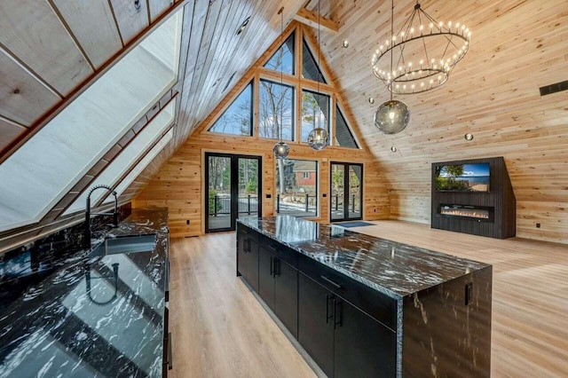 4142 Calendula Ct, Pocono Pines, PA 18350 - kitchen featuring wood walls, french doors, dark cabinetry, light wood-style flooring, and a chandelier