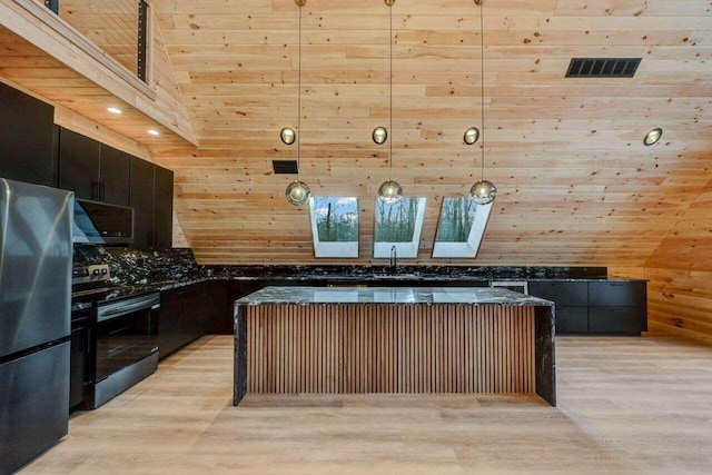 4142 Calendula Ct, Pocono Pines, PA 18350 - kitchen featuring stainless steel appliances, wood walls, light wood finished floors, a skylight, and decorative light fixtures