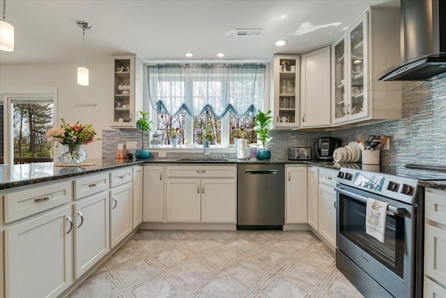 116 Red Bud Ln, Kunkletown, PA 18058 - kitchen featuring stainless steel appliances, wall chimney exhaust hood, tasteful backsplash, dark stone counters, and decorative light fixtures
