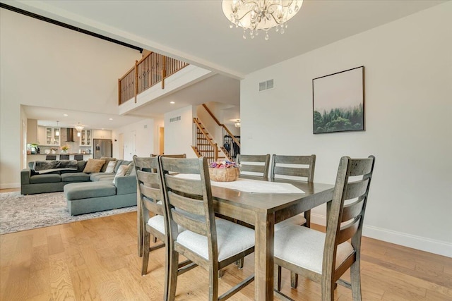 116 Red Bud Ln, Kunkletown, PA 18058 - dining space featuring a chandelier, stairs, and light wood-style floors
