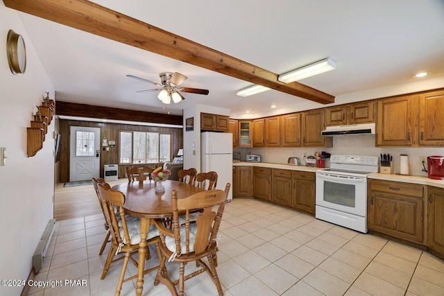 kitchen with white appliances, brown cabinetry, beam ceiling, light countertops, and under cabinet range hood