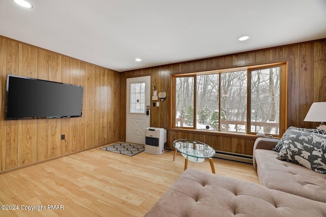 living area with recessed lighting, baseboard heating, wood finished floors, and wooden walls