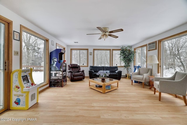 living area featuring wood finished floors, visible vents, a wall mounted air conditioner, and ceiling fan