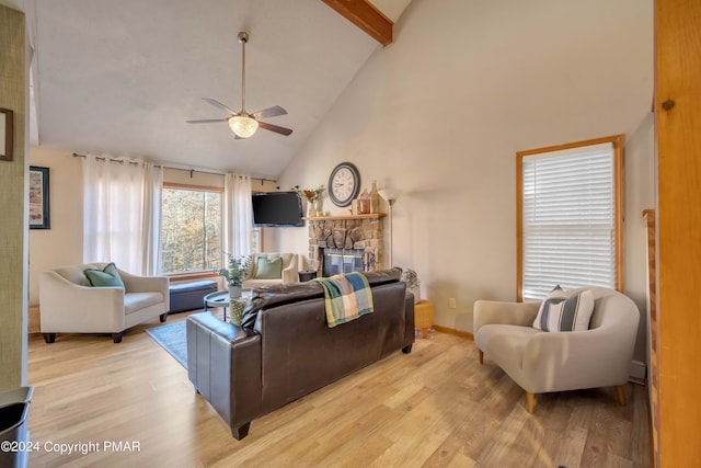 living room with light wood-type flooring, high vaulted ceiling, beamed ceiling, and a stone fireplace