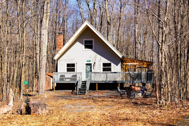 rear view of property featuring a deck and a chimney