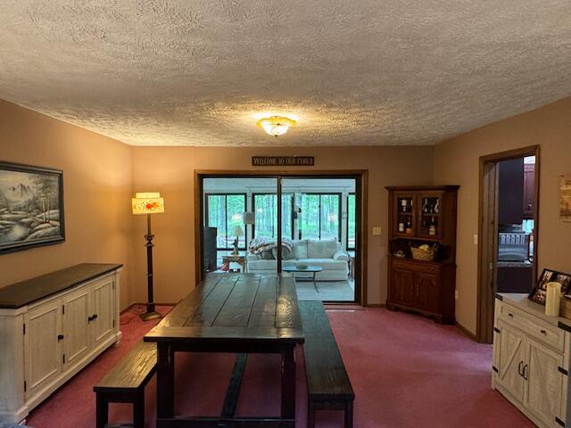 122 Sawmill Rd, Pocono Lake, PA 18347 - dining space with a textured ceiling and dark carpet