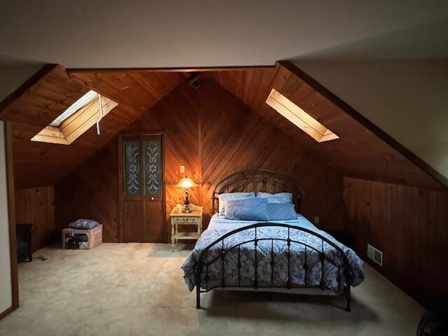 122 Sawmill Rd, Pocono Lake, PA 18347 - carpeted bedroom featuring a skylight, wood walls, and vaulted ceiling