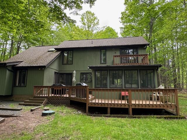 122 Sawmill Rd, Pocono Lake, PA 18347 - back of house featuring a balcony, a sunroom, a yard, and a shingled roof