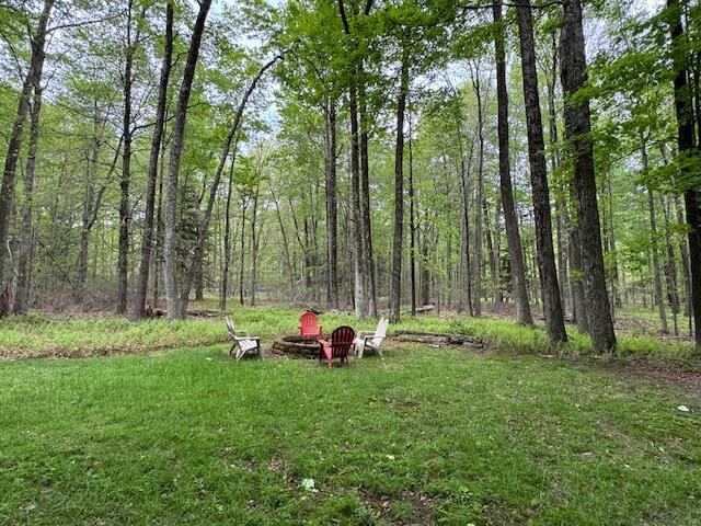 122 Sawmill Rd, Pocono Lake, PA 18347 - view of grassy yard with an outdoor fire pit and a view of trees
