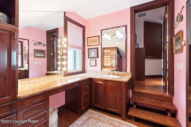 bathroom with visible vents, wood finished floors, and vanity