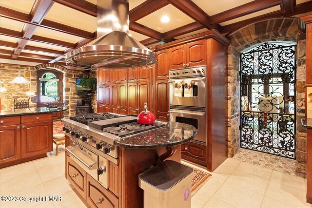 kitchen featuring cooktop, stainless steel double oven, island range hood, dark stone counters, and coffered ceiling