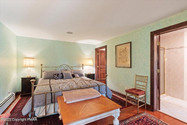 bedroom with a baseboard radiator and wood finished floors