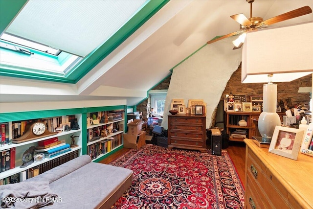 bonus room featuring ceiling fan, vaulted ceiling with skylight, and wood finished floors