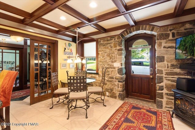 foyer entrance featuring a wood stove, coffered ceiling, beam ceiling, and french doors