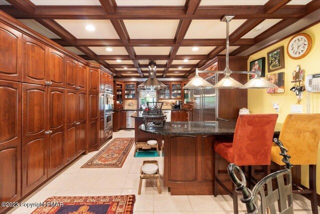 kitchen featuring a center island, glass insert cabinets, coffered ceiling, beamed ceiling, and a kitchen bar