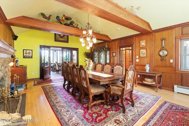 dining room featuring lofted ceiling with beams, wood walls, light wood-style floors, and a notable chandelier