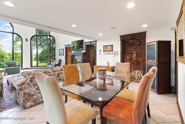 dining area with light tile patterned floors, a premium fireplace, and recessed lighting