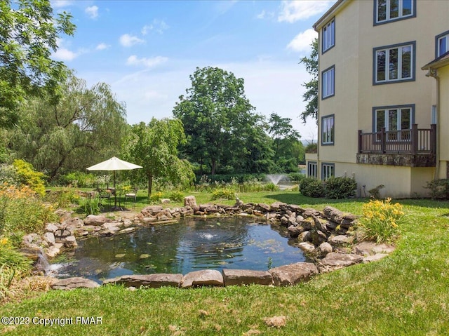 exterior space with a small pond and a yard