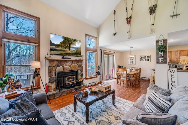 living room featuring a healthy amount of sunlight, baseboard heating, and wood finished floors