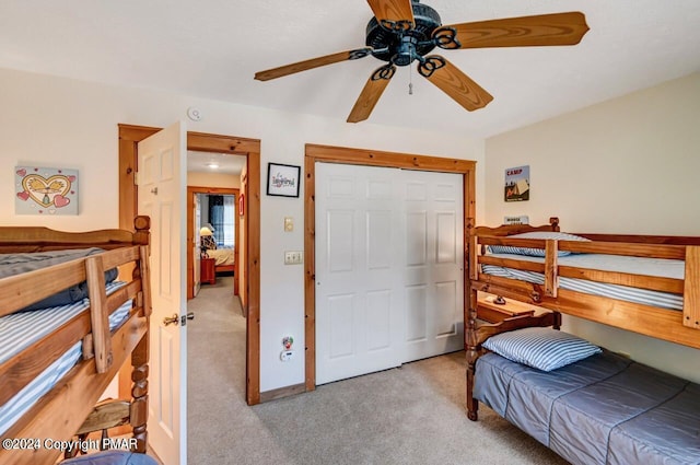 carpeted bedroom featuring baseboards, a ceiling fan, and a closet